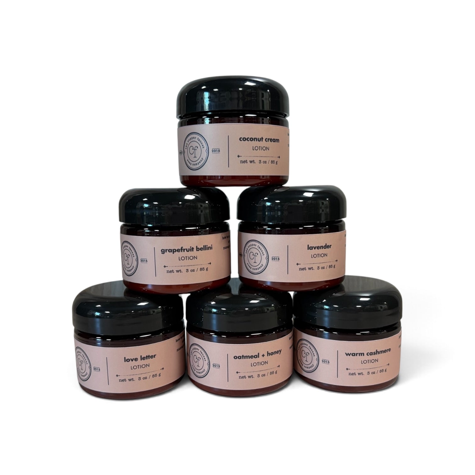 Lotions arranged in a pyramid with scents of coconut cream, grapefruit bellini, lavender, love letter, oatmeal + honey and warm cashmere