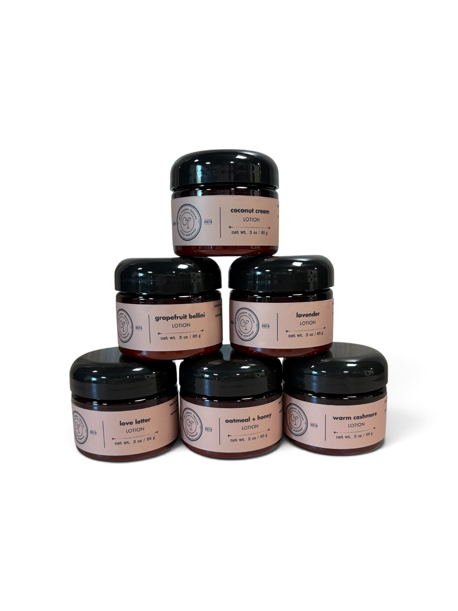 Lotions arranged in a pyramid with scents of coconut cream, grapefruit bellini, lavender, love letter, oatmeal + honey and warm cashmere